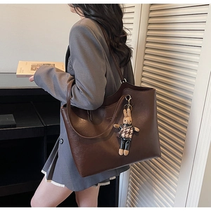 Détail d'un grand cabas vintage marron avec breloque lapin porté à l'épaule sur mesure