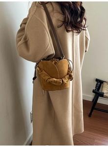 Détail d'un sac seau en daim marron avec design tulipe et poignée plissée élégante