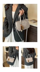 Détail du sac à main beige texturé avec motif gaufré unique et breloque en perles de bois