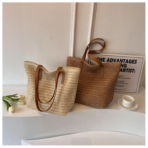 Détail de sacs fourre-tout en paille tissée main avec anses en cuir beige et marron