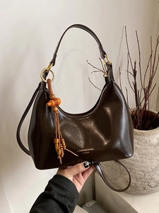 Dark brown faux leather crescent hobo bag with adjustable strap and beaded charm