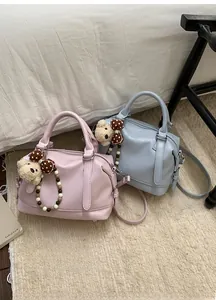 Detail of pink and blue Boston bags featuring cute plush bear charms and bead tassels