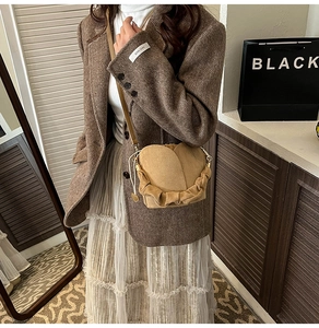 Détail d'un sac seau plissé kaki avec cordon de serrage assorti à une tenue vintage