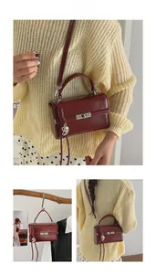 Detail of burgundy vintage crossbody bag featuring silver turn-lock and heart charm