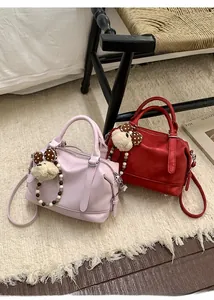 Detail of pink and dark red Boston bags in soft leather with cute bear charms