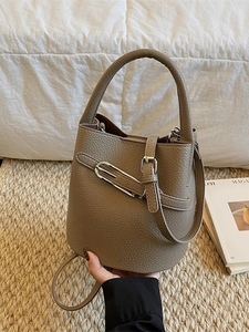 Sac seau minimaliste en cuir grainé taupe avec détails argentés et bandoulière