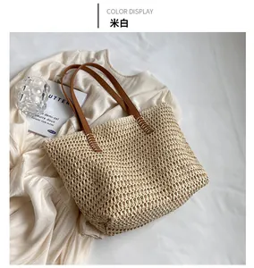 Détail d'un cabas tressé crème avec poignées en cuir marron et coutures raffinées