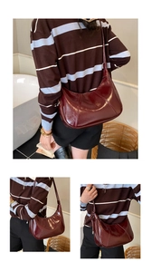Macro view of cherry red patent leather crescent bag with detailed diagonal stitching