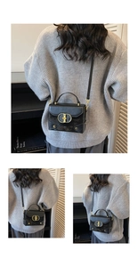 Detail of structured black crossbody bag with gold buckle on a grey sweater model