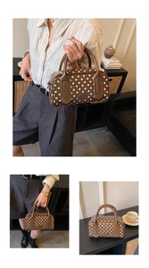 Close-up of brown Boston handbag with white polka dots and dual top handles