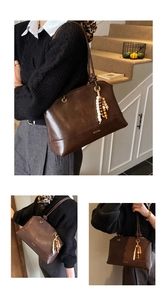 Λεπτομέρεια vintage καφέ δερμάτινης τσάντας tote με κρεμαστό με χάντρες και λογότυπο