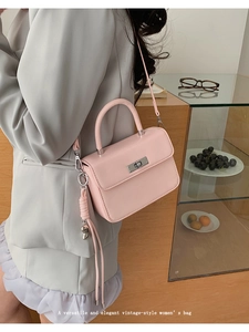 Pink vintage crossbody bag featuring silver turn-lock and knot detail shown on a model