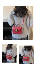 Detail view of red vintage crossbody box bag with gold metal buckle and leather strap