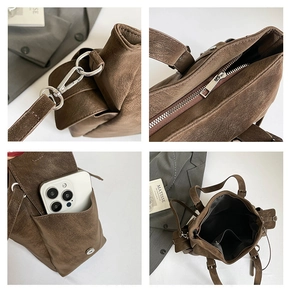 Detail view of the vintage leather tote bag showing zippers, straps, and inner pockets