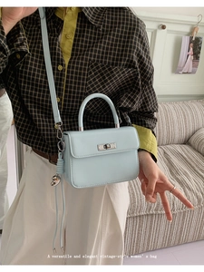Detail of light blue vintage square handbag with silver metal lock and heart charm