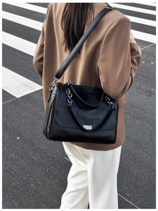 Macro detail of black quilted leather shoulder bag with silver chain and metal hardware