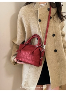 Red retro leather Boston bag styled with a beige coat for a minimalist look