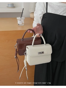 Close-up of vintage-style women's handbag with metallic rotating lock and woven details