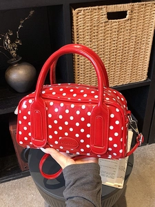 Chic red polka dot handbag with top handle and adjustable strap in glossy finish