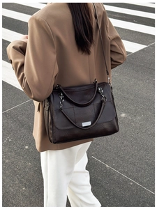 Close-up of vintage chocolate brown pleated leather crossbody bag with silver chain handle