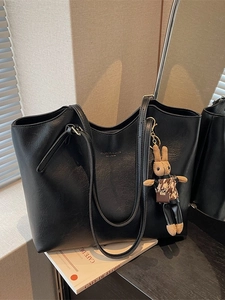 Grand sac cabas noir en cuir grainé avec texte doré et pendentif lapin sur des livres