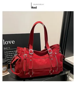 Close-up of stylish red tote bag with metallic buckles on a black display shelf