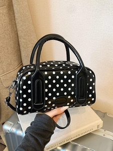Polka dot handbag in black and white with glossy finish and detachable shoulder strap