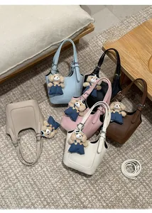 Flat lay of minimalist mini bucket bags in six colors with teddy bear charms and straps