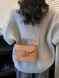 Vintage brown crossbody box bag with gold buckle and adjustable strap shown on model