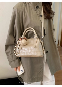 Minimalist beige faux leather Boston bag featuring a mushroom pendant and bead charm