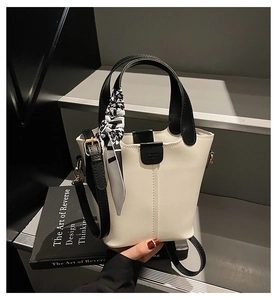 Detail of white bucket bag featuring houndstooth scarf and fashion magnetic closure