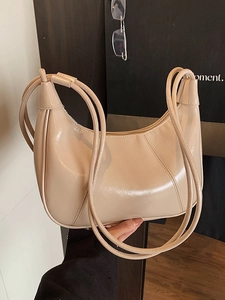 Minimalist beige glossy patent leather crescent shoulder bag with slim straps