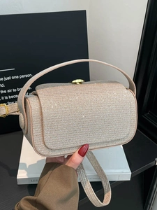 Champagne gold glitter crossbody box bag with top handle shown in a hand-held close-up view