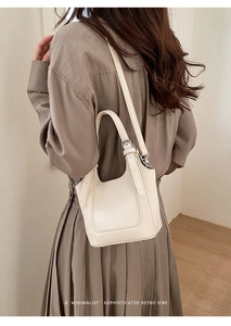Detailed close-up of white lychee grain leather bucket bag with silver metal hardware