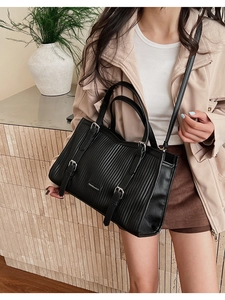 Detail of black PU leather tote with pleated texture and adjustable shoulder strap
