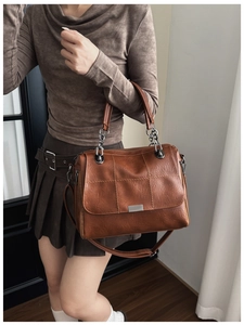 Detail of vintage brown textured faux leather bag with square stitching and silver hardware