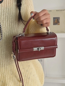 Chic burgundy patent leather handbag with silver lock and decorative knot detail