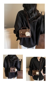 Detail of vintage brown leather crossbody bag with gold buckles and plush charm
