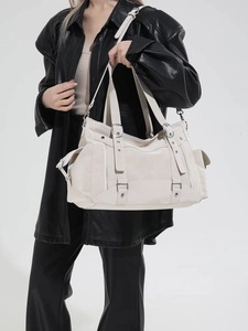 Off-white faux leather tote bag with silver hardware and multiple zipper pockets