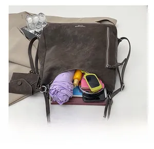 Detailed top view of a large brown tote bag interior with umbrella, books, and cosmetics