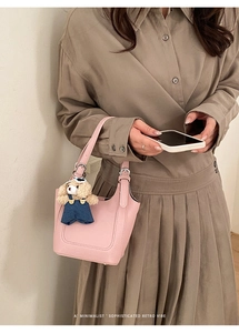 Pink lychee grain leather bucket bag with cute dog charm and adjustable handle strap