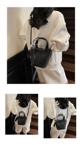 Detail of black glossy leather bucket bag with houndstooth scarf and long strap