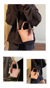 Detail of pink bucket bag featuring branded logo, ribbon handle, and detachable strap