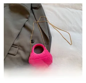 Detail of rose pink velvet handbag with geometric triangle embossing and gold chain