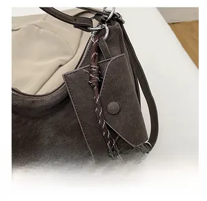 Macro view of dark brown litchi textured leather tote with woven detail and metal ring