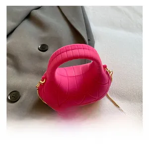 Detail of pink quilted handbag with velvet texture and elegant gold chain strap