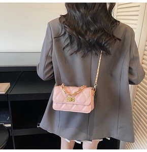 Vue de dos d'un mannequin portant un sac bandoulière rose matelassé à chaîne dorée
