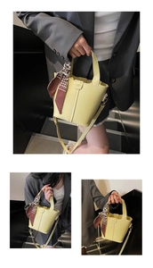 Detail of pale yellow leather bucket bag with houndstooth scarf and adjustable strap