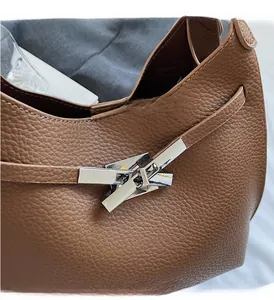 Detail of silver geometric buckle and brown lychee grain leather on bucket handbag