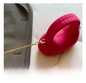 Detail view of pink quilted handbag showing gold chain strap and lobster clasp